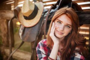 close-up-portrait-happy-beautiful-redhead-cowgirl-resting-ranch-fence-78258183
